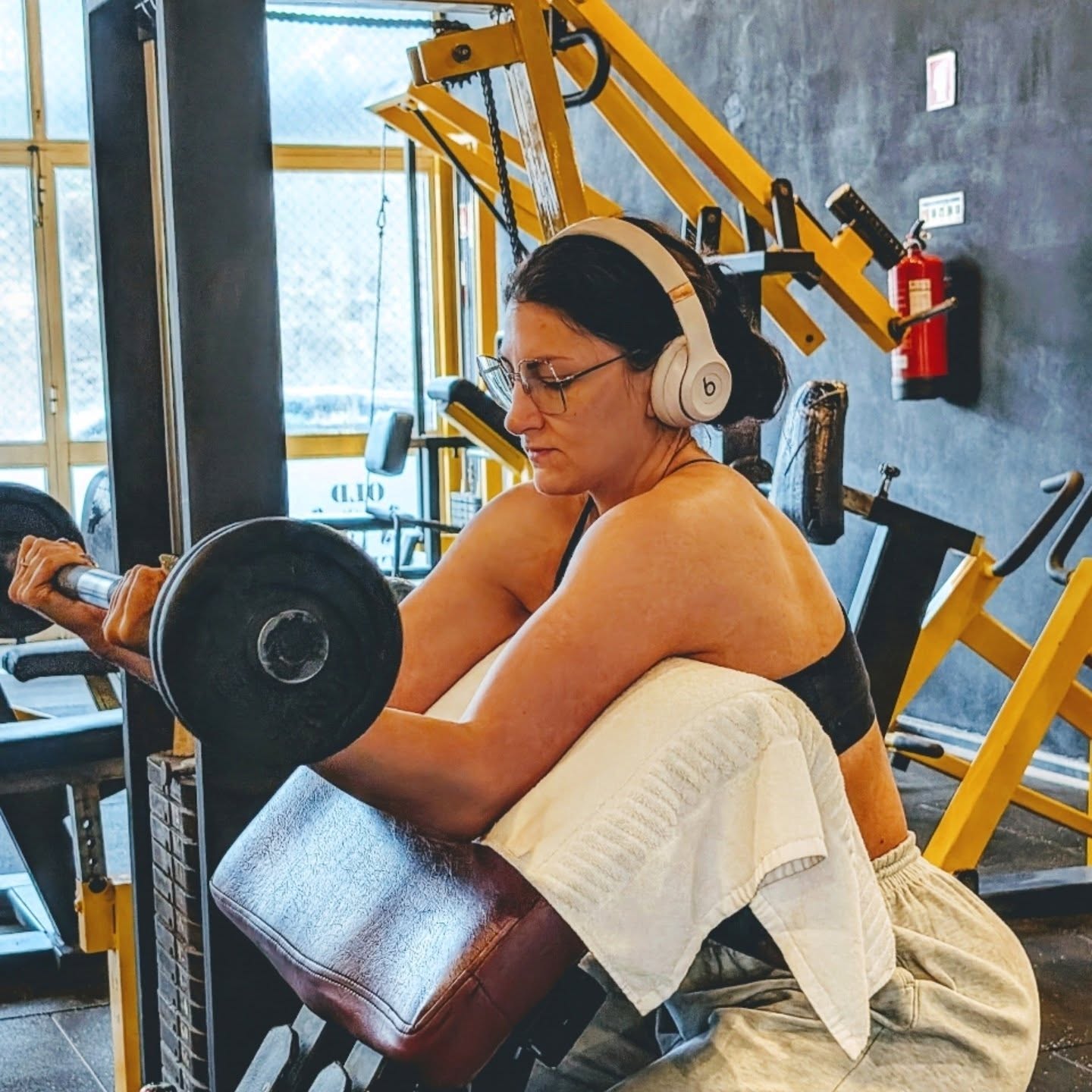 Yana Gisin doing preacher curls in the gym